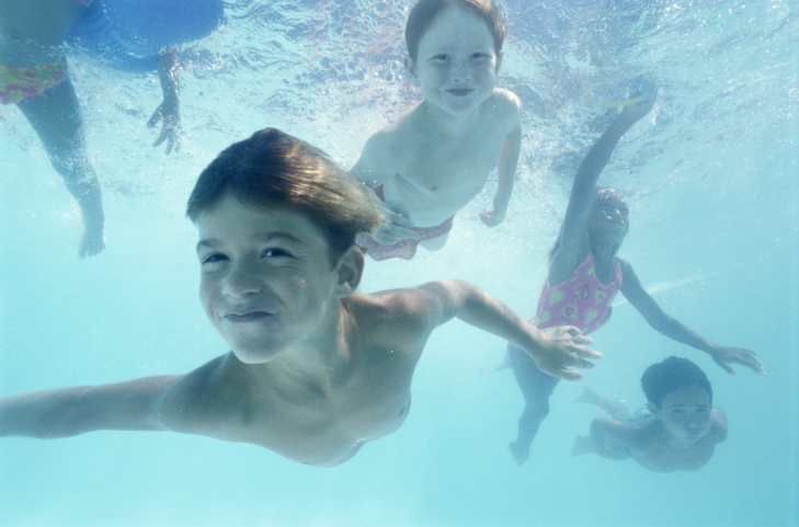 children swimming in above ground pool